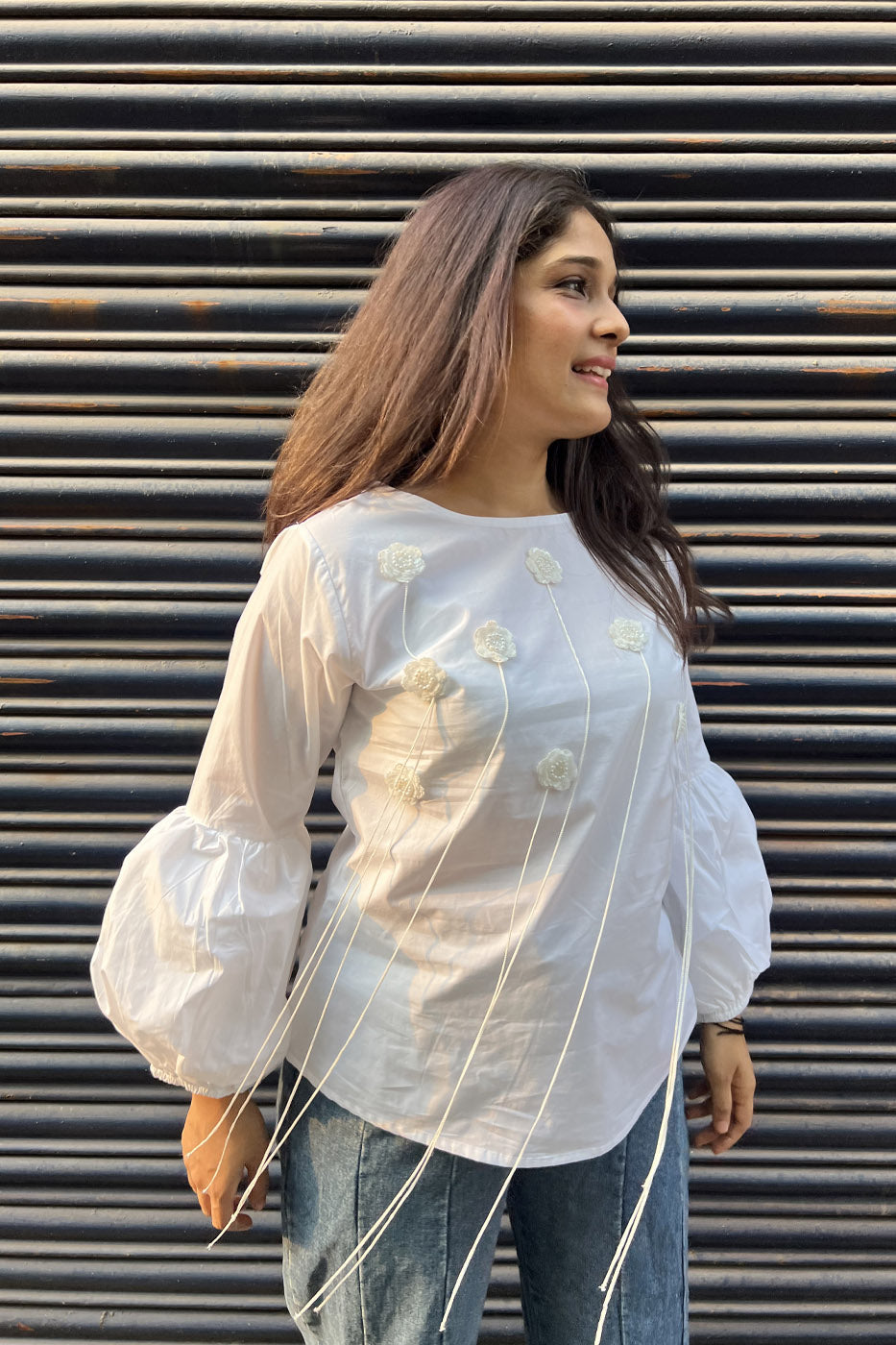 White top with flower and tassel detail