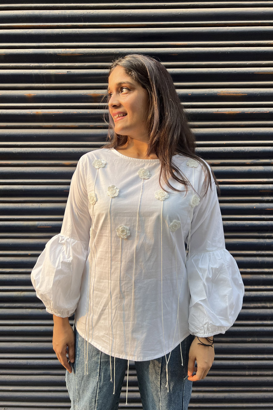 White top with flower and tassel detail