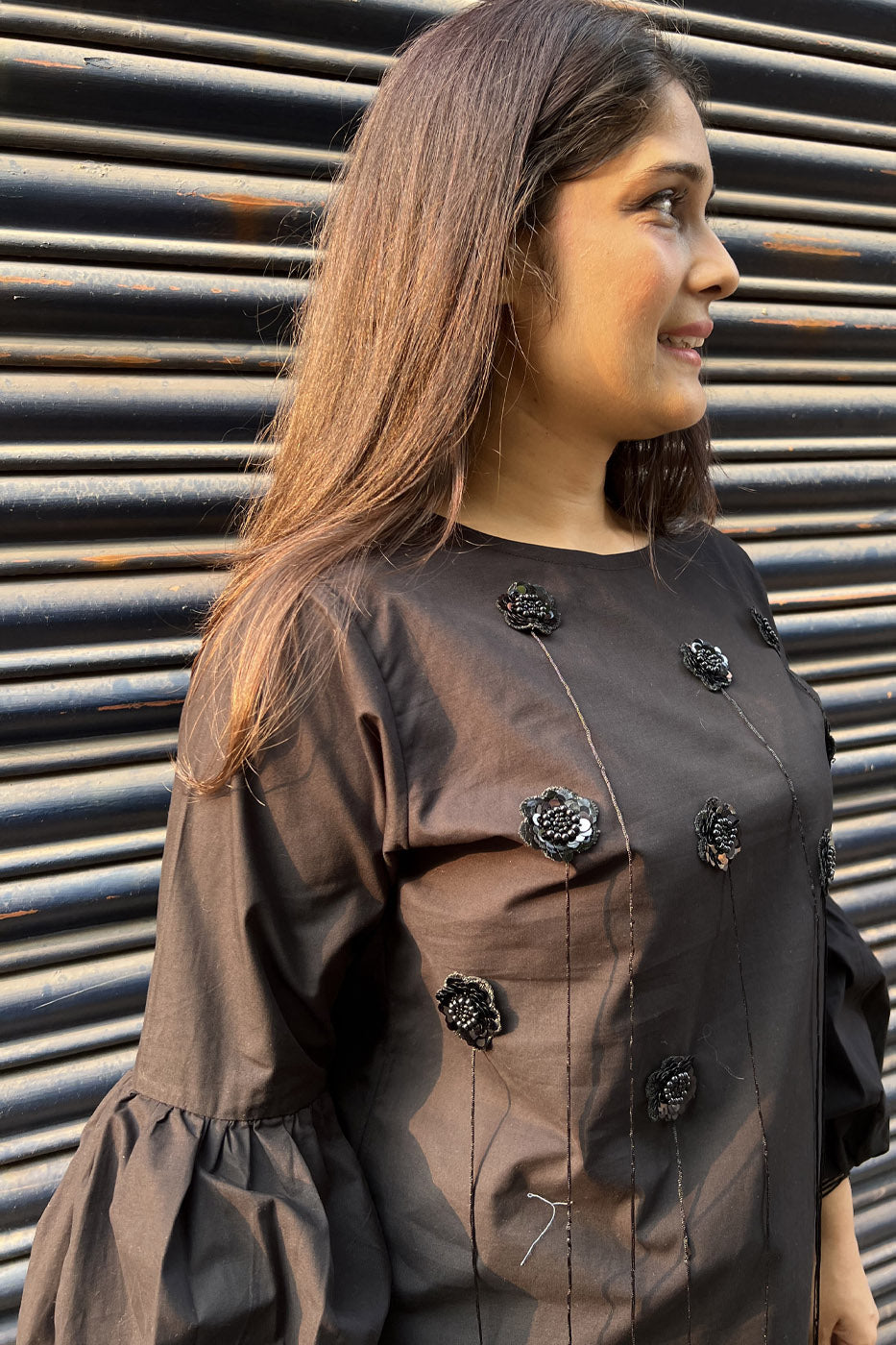 Black top with flower and tassel detail