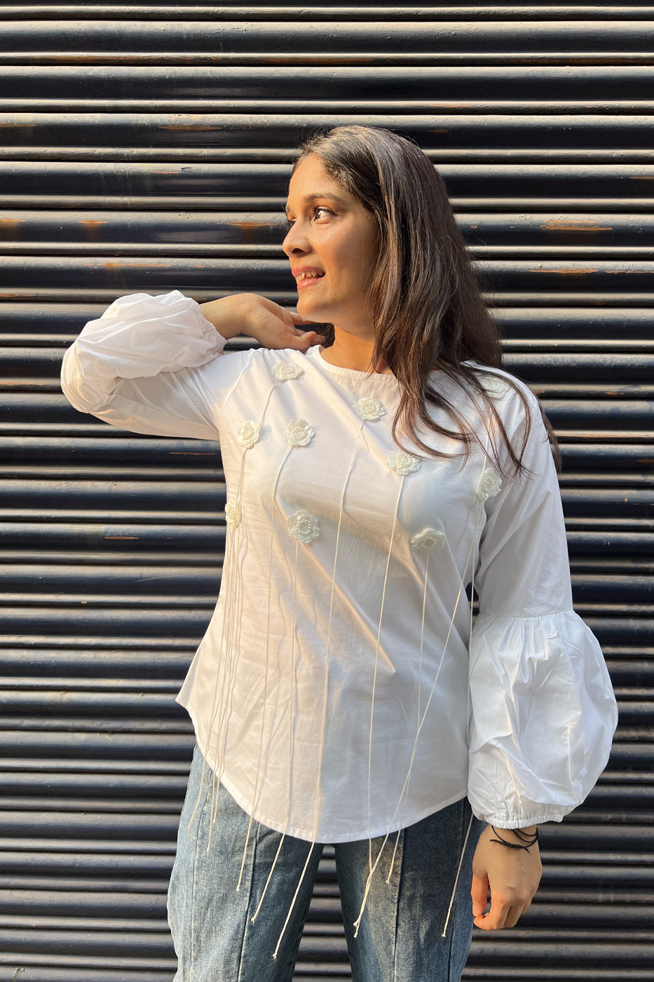 White top with flower and tassel detail