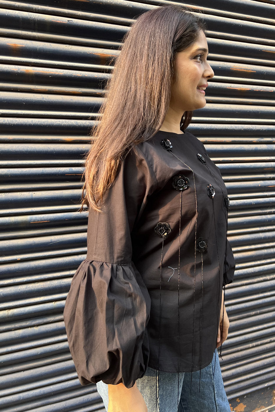 Black top with flower and tassel detail