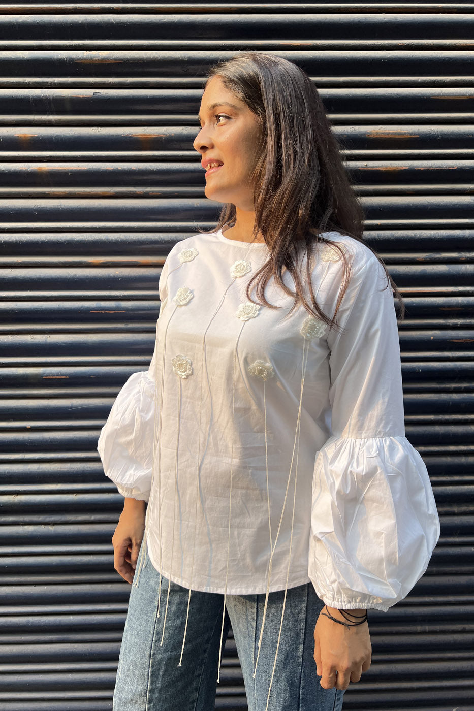 White top with flower and tassel detail