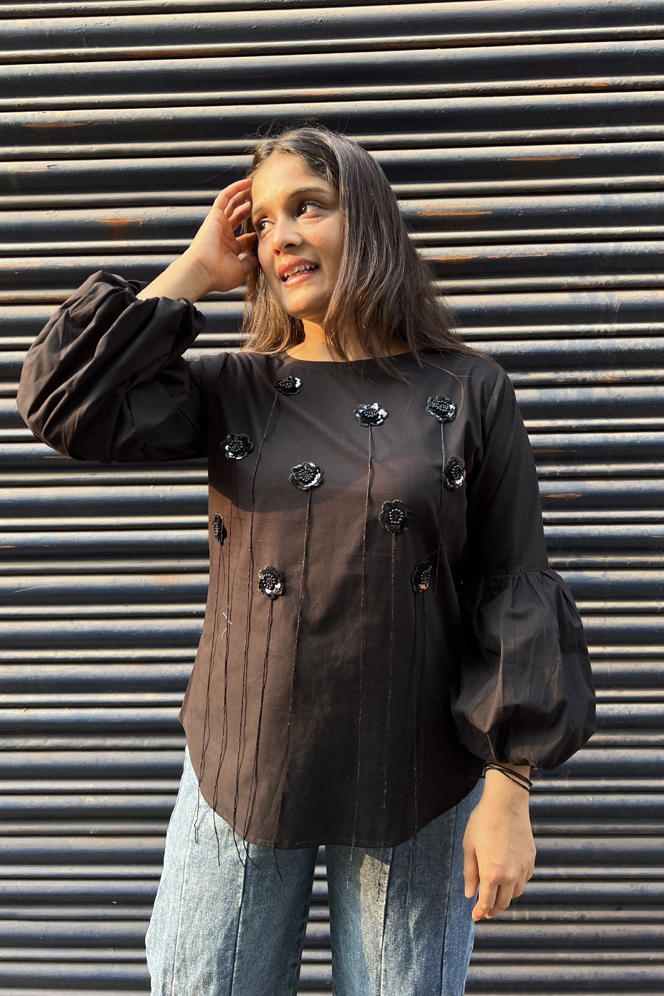 Black top with flower and tassel detail